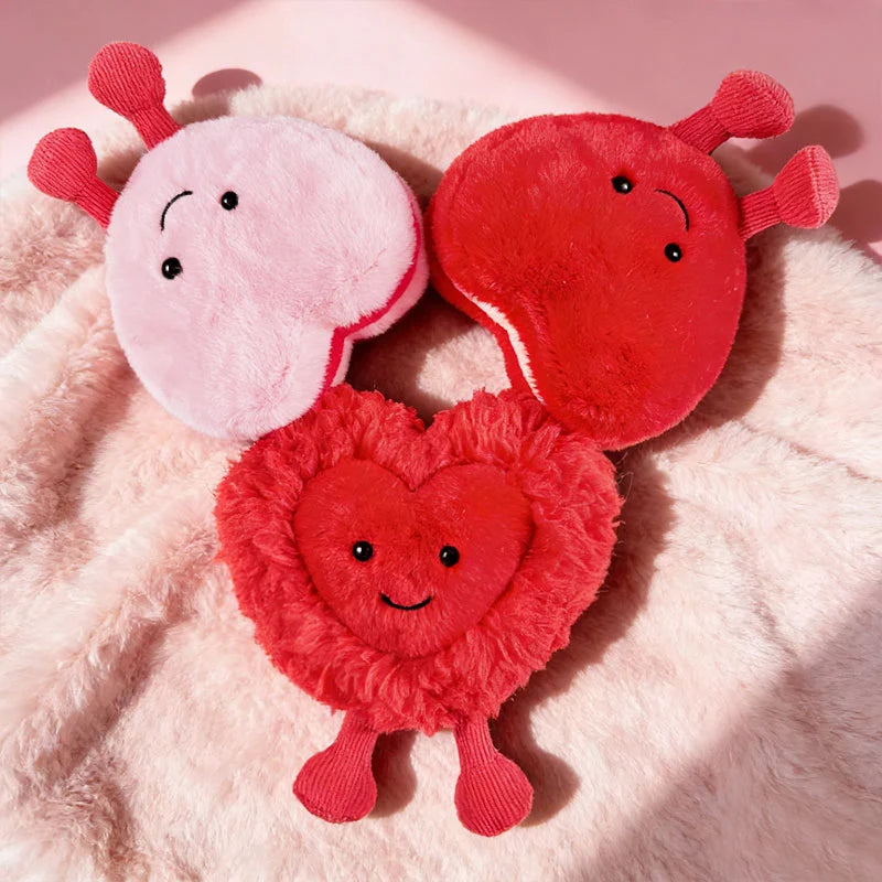 Three kawaii plush toys shaped like hearts and a circle on a pink fluffy background