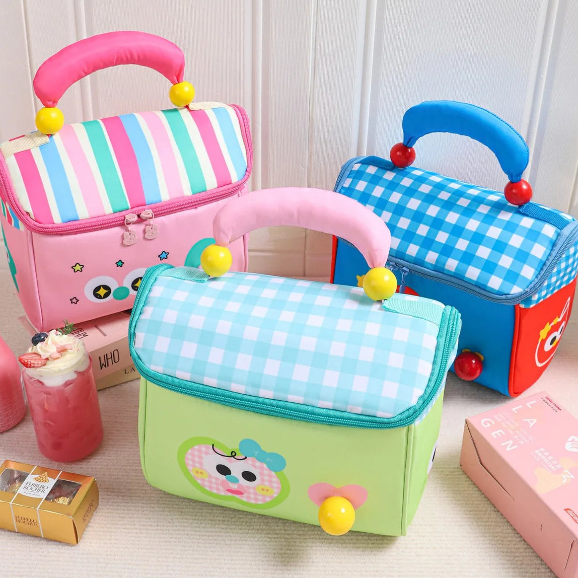 Three colorful children's kawaii bags with cartoon designs on a light wooden surface.