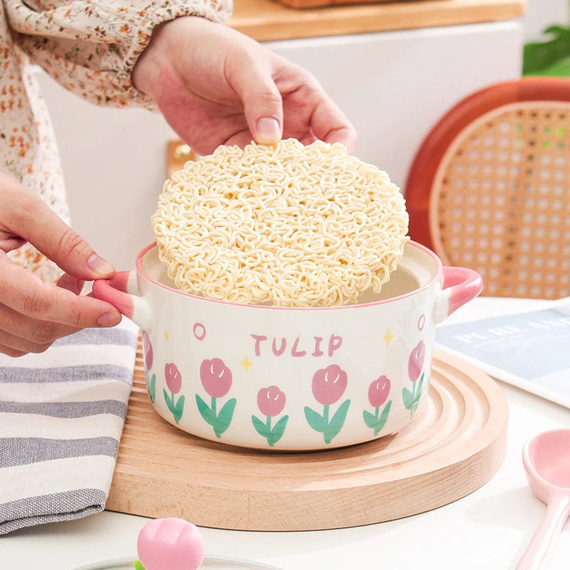 Someone placing ramen into a tulip design kawaii ramen bowl