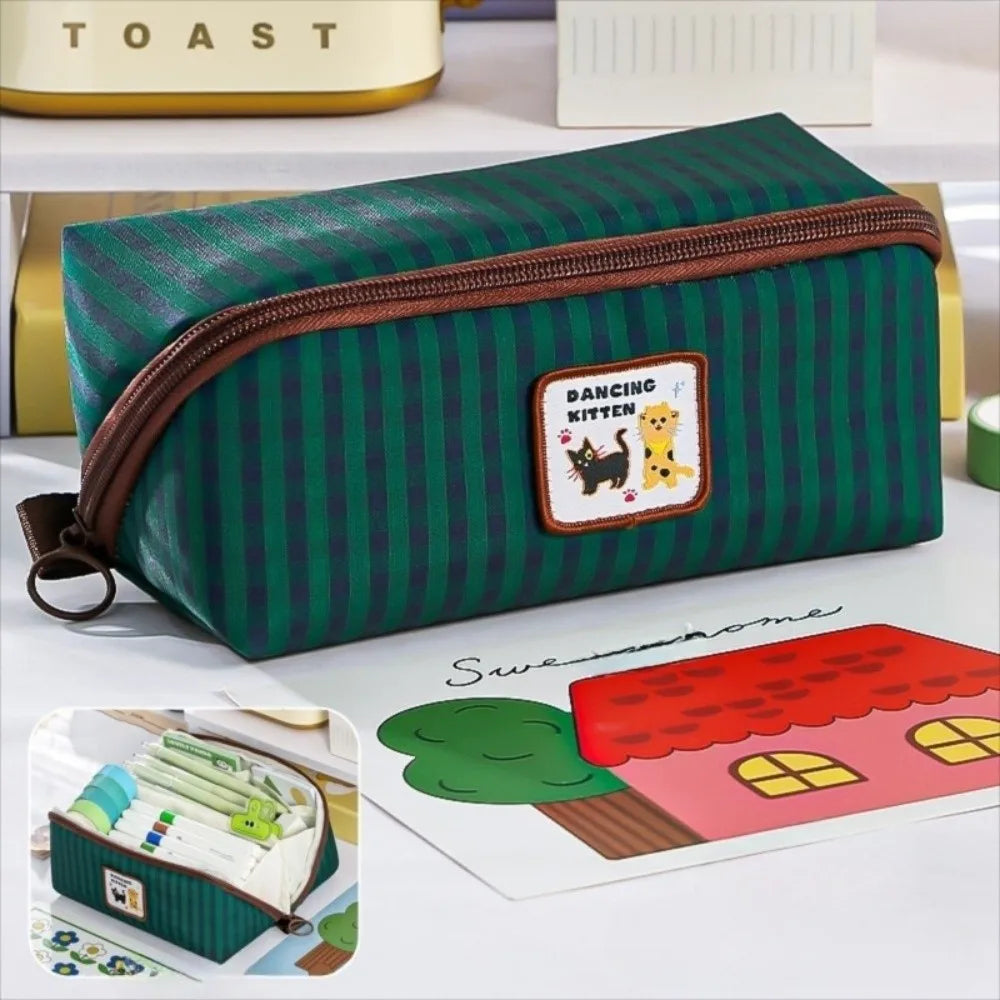 Green striped kawaii pencil case with a patch on a white surface