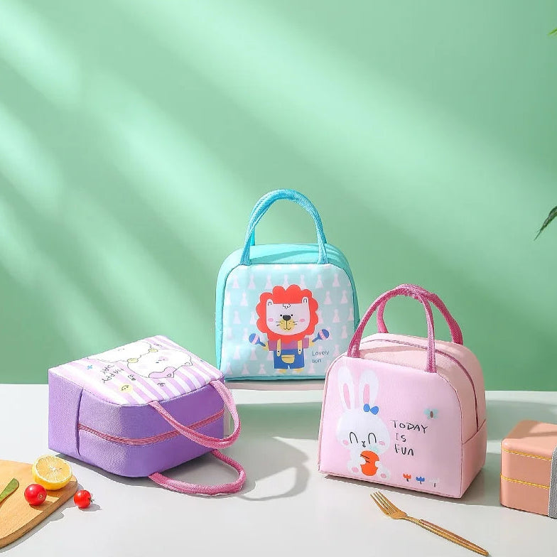 Three colorful kawaii lunch bags on a light surface with a green background