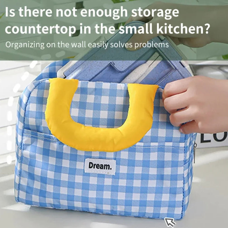 Blue checkered kawaii bag with yellow handle held by a hand on a white surface.