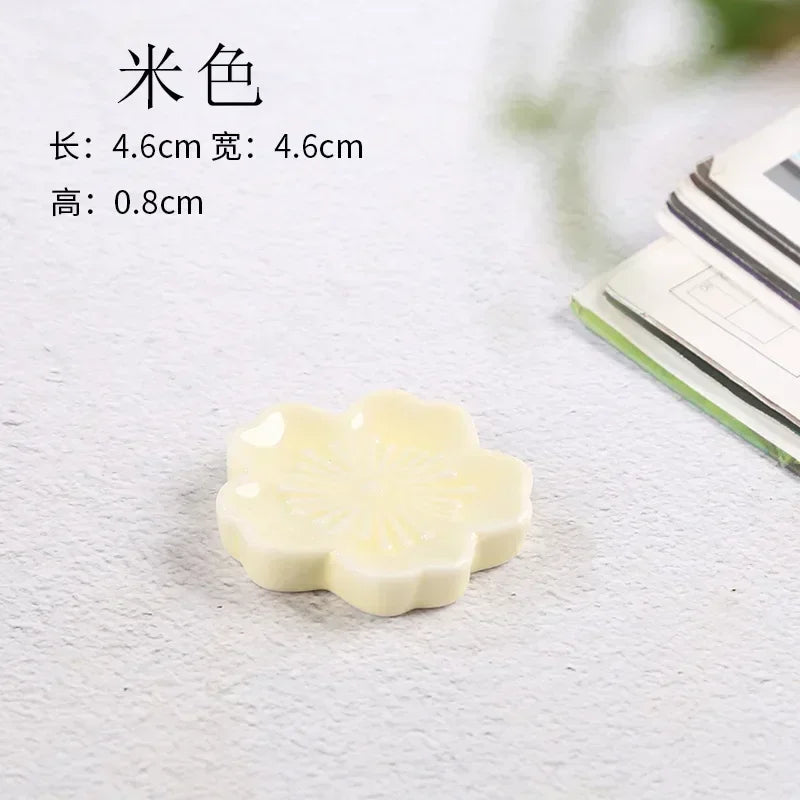 Small white flower-shaped kawaii chopstick holder on a textured surface with dimensions displayed.