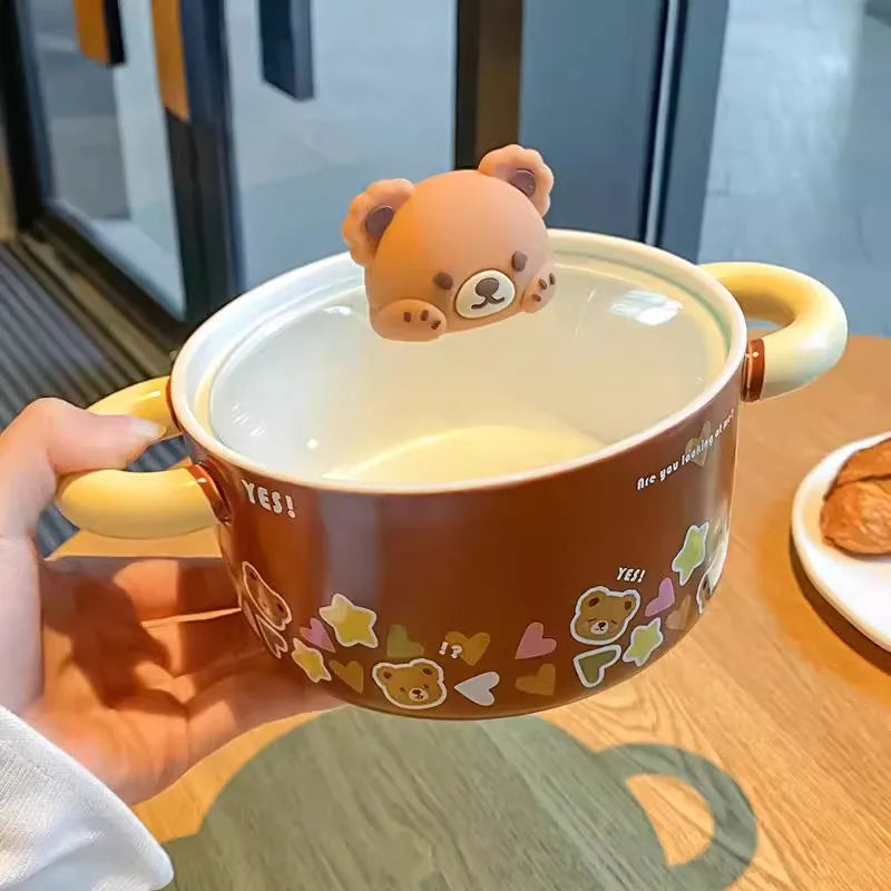 Ceramic kawaii ramen bowl with bear design and lid, held by a hand on a wooden table.