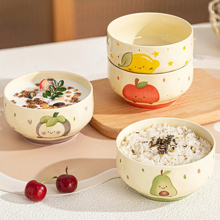 Set of ceramic kawaii bowls with fruit designs on a wooden board