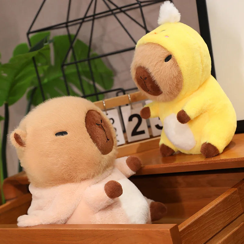 Two kawaii plush toys, one resembling a lion and the other a duck, sitting on a wooden surface with a plant and decorative items in the background.