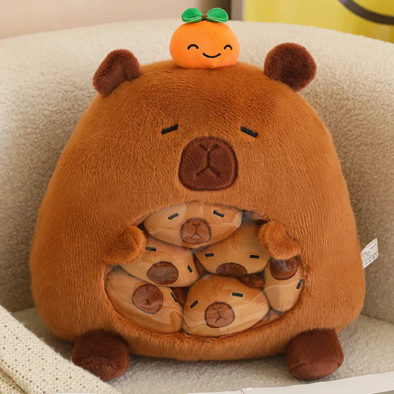 Kawaii plush bear toy with small plush bears inside and an orange on top, sitting on a beige surface.