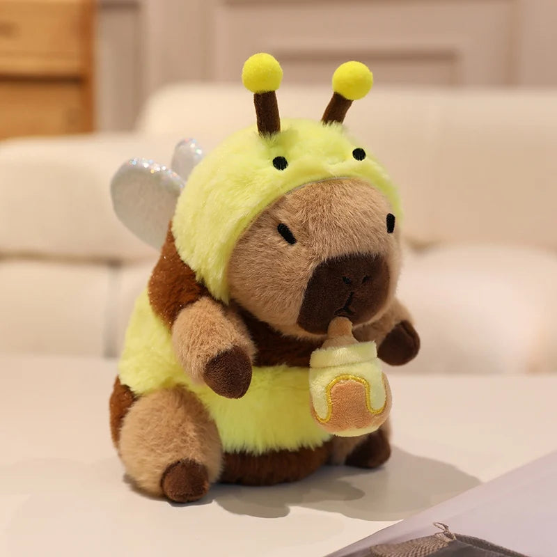 Kawaii plush toy resembling a bee holding a bottle on a light-colored surface.