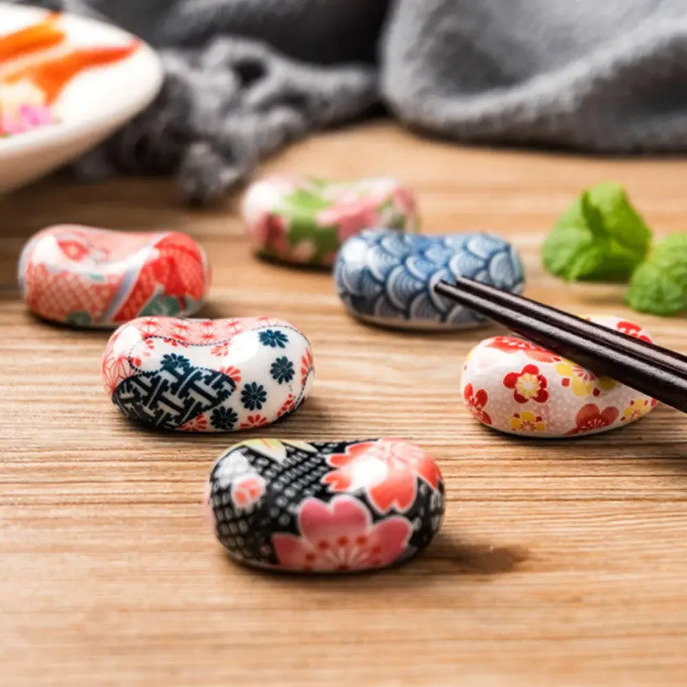 Colorful decorative kawaii chopstick holders on a wooden surface with chopsticks.