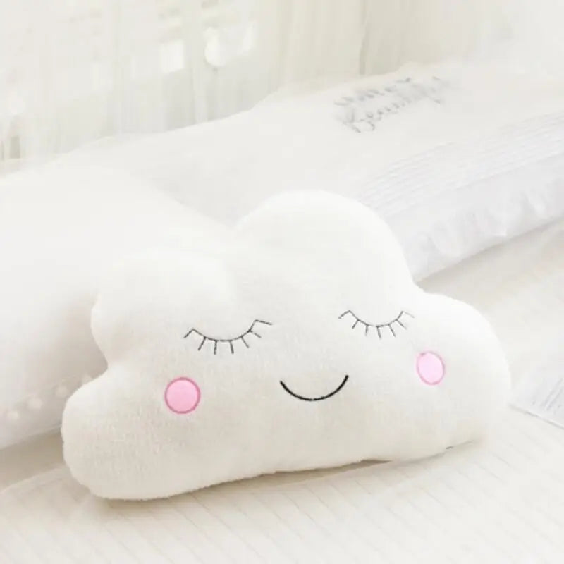 White cloud-shaped kawaii pillow with a smiley face on a light background