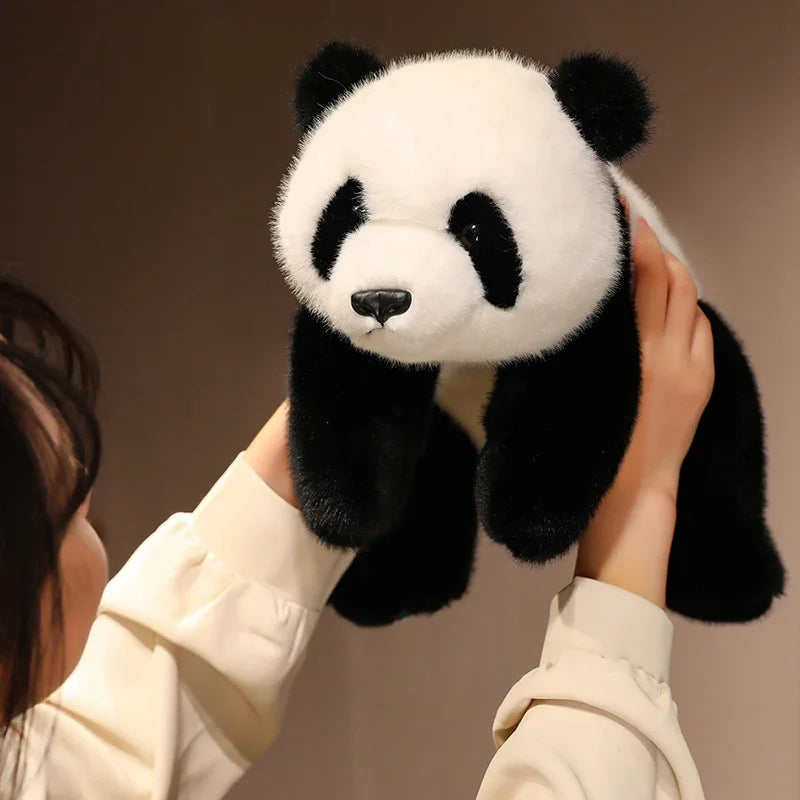 Person holding a kawaii plush panda toy against a neutral background