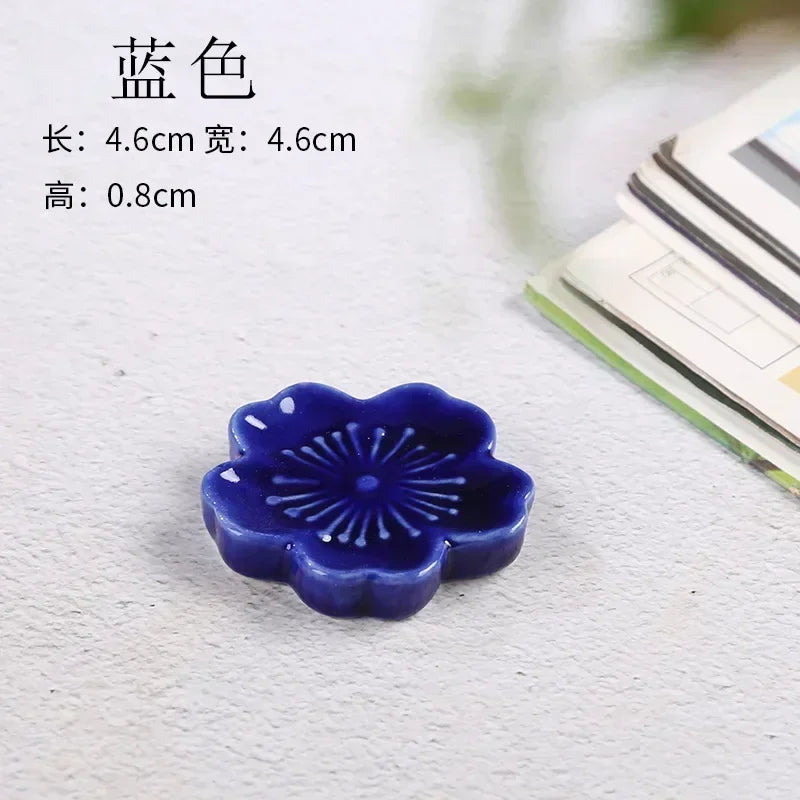 Blue ceramic flower-shaped kawaii chopstick holder on a light gray background with text