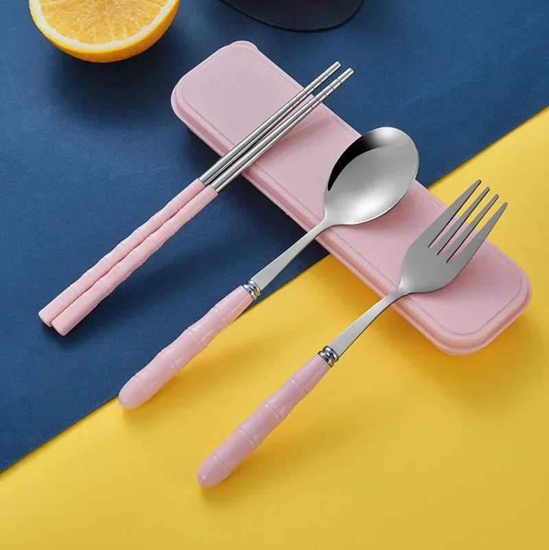 A set of pink and steel kawaii utensils on a table