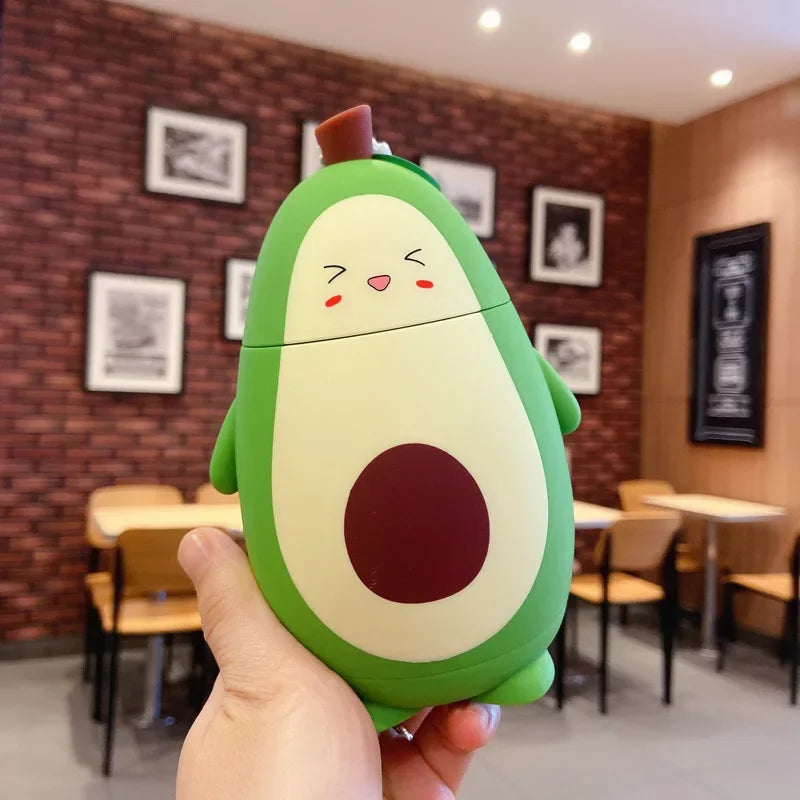 Avocado-shaped kawaii water bottle held in front of a restaurant interior with brick walls and framed pictures.