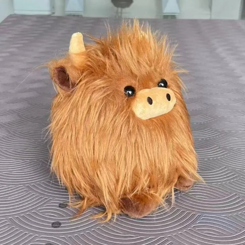 Plush kawaii toy resembling a Highland cow on a textured surface