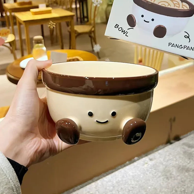 A white kawaii bowl with a smiley face being held by a person