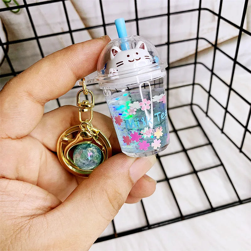 Clear drink container with kawaii cat design held by a hand, against a grid background