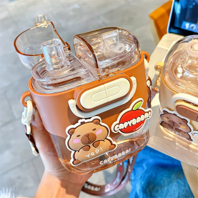 Clear kawaii water bottle with brown lid and bear stickers, held by a hand.