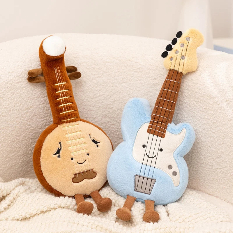Two kawaii plush toys resembling a banjo and a guitar on a soft surface