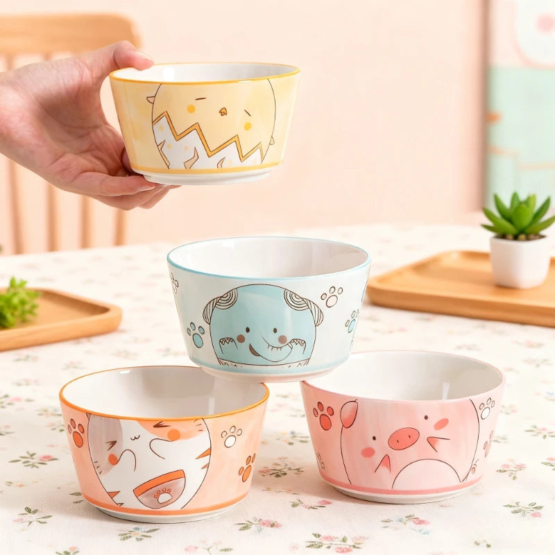 Four kawaii bowls on a table with cartoons designed on them