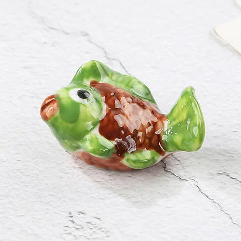 Small green and brown ceramic turtle kawaii chopstick holders on a light gray surface with text indicating dimensions.