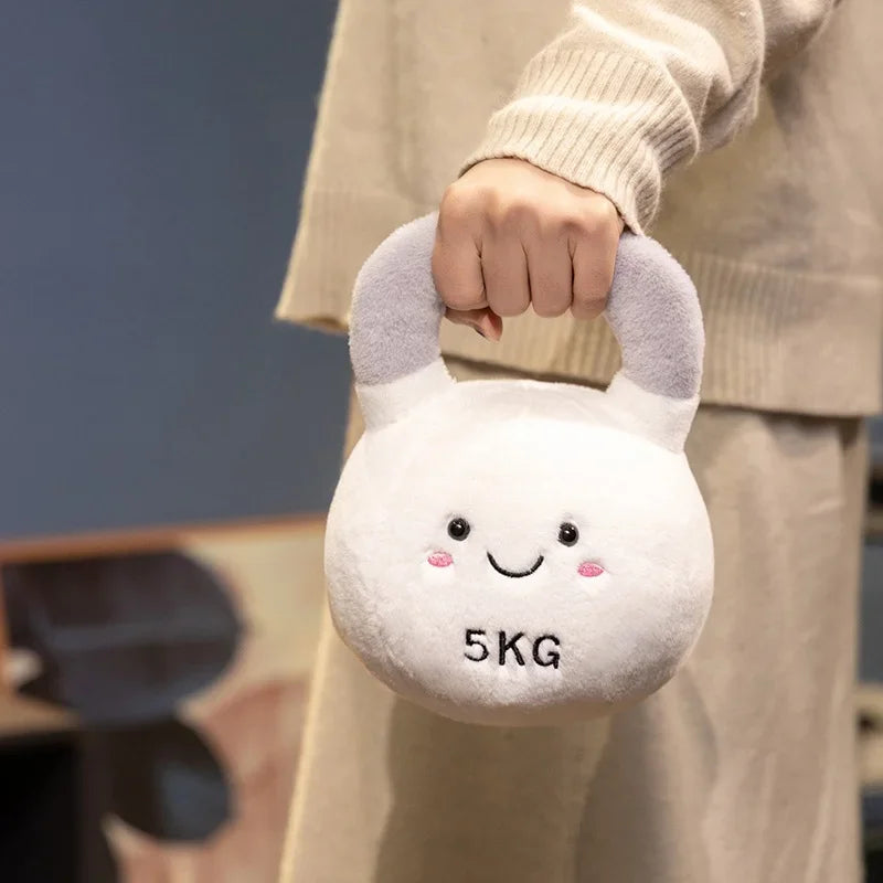 Kawaii plush toy kettlebell with a smiley face and '5KG' label held by a person.