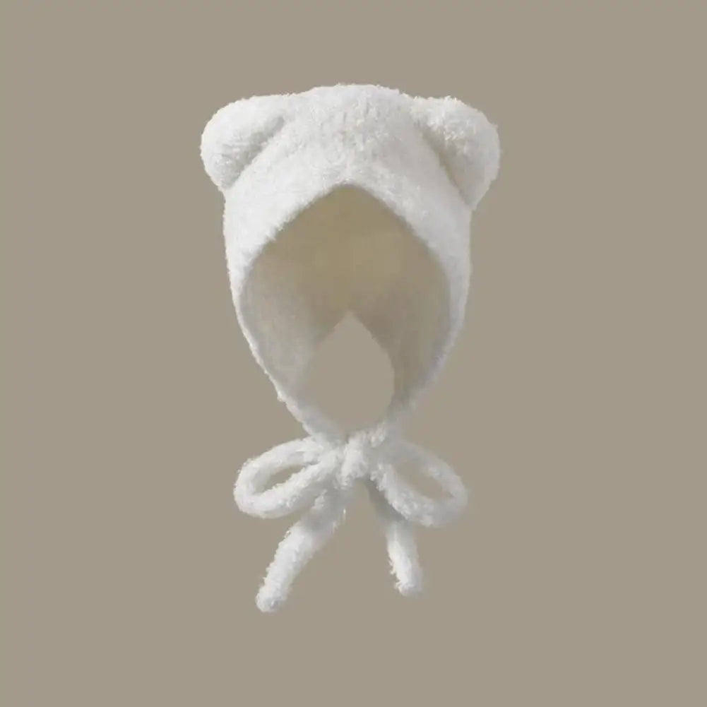 White baby Kawaii bonnet with bear ears on a beige background