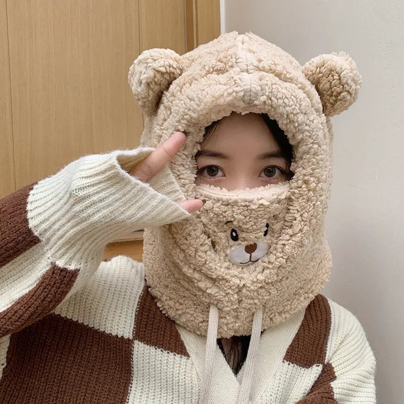 Person wearing a Kawaii bear-themed hood and gloves in front of a wooden door.
