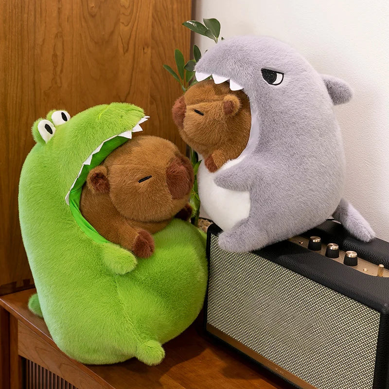 Two kawaii plush toys, one green dinosaur and one gray shark, sitting on a wooden surface.