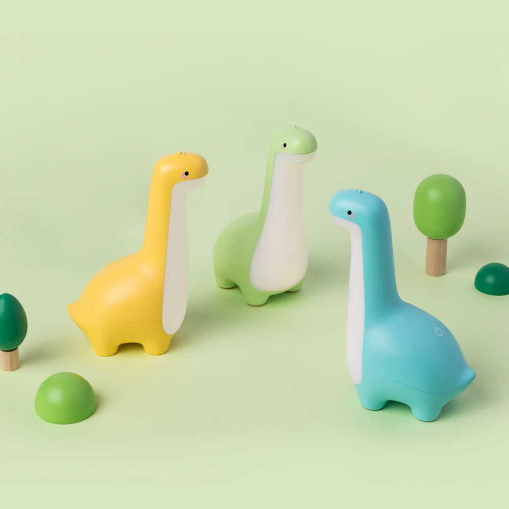 Three colorful dinosaur kawaii night lights on a light green background