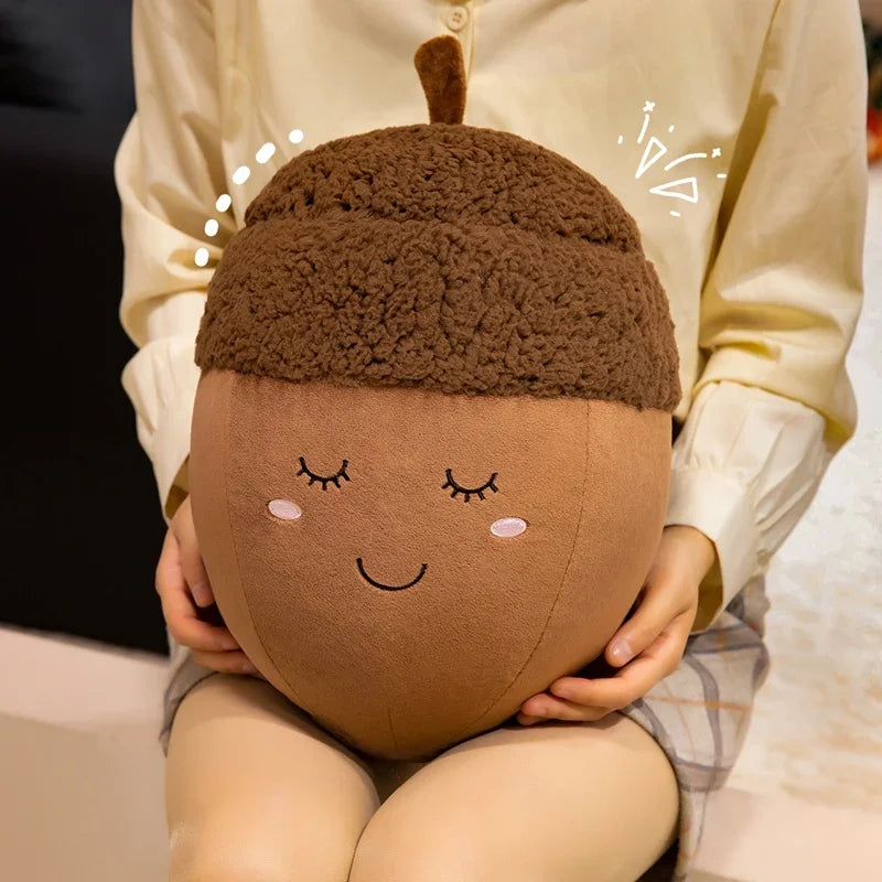 Person holding a kawaii plush acorn-shaped pillow with a smiling face design.