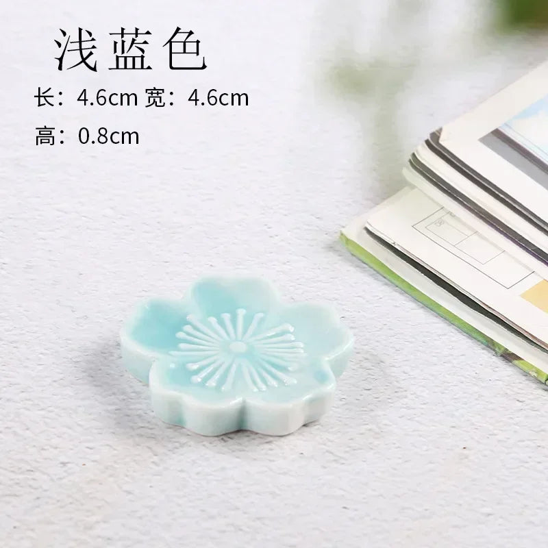 Light blue flower-shaped kawaii chopstick holder on a textured surface with text overlay