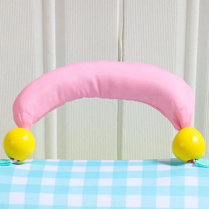 Pink arch-shaped handle with yellow balls on a checkered kawaii lunch bag against a white background