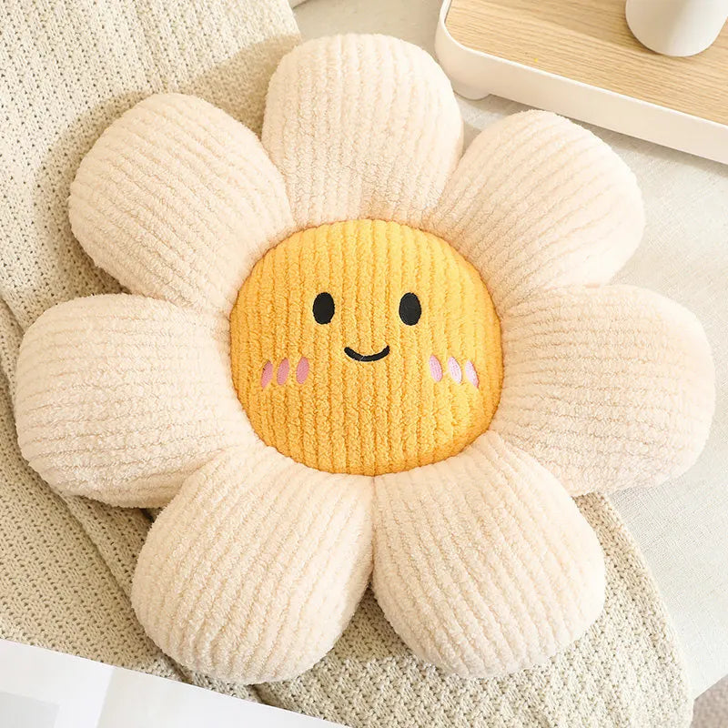Flower-shaped kawaii plush toy with a smiling face on a soft surface
