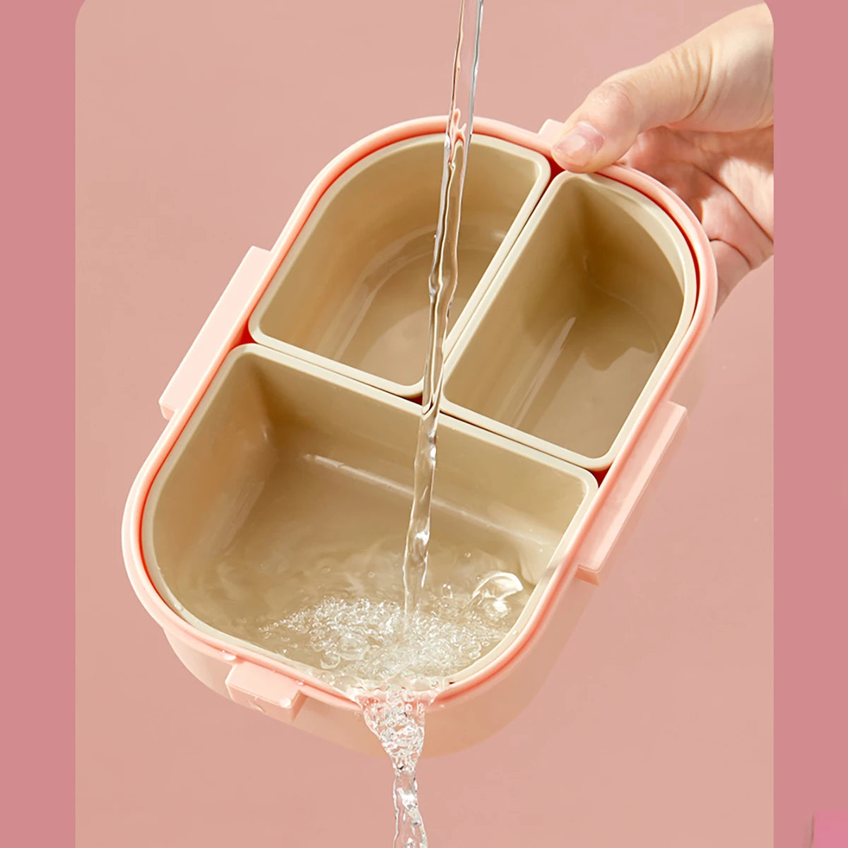 Beige kawaii bento box with compartments being filled with water on a pink background