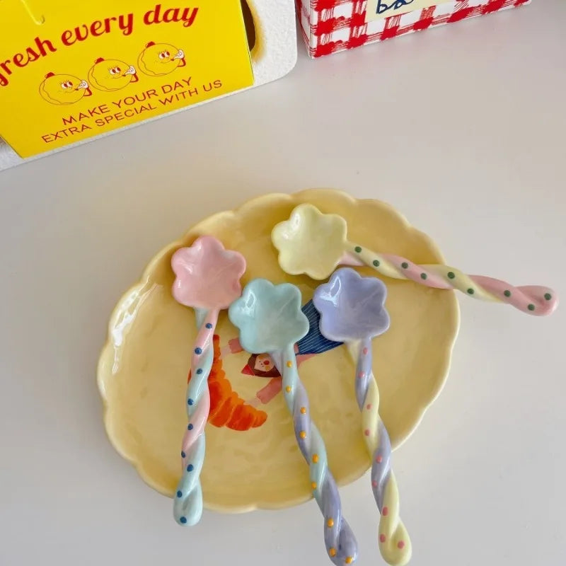 Four rainbow designed ceramic kawaii spoons on a plate
