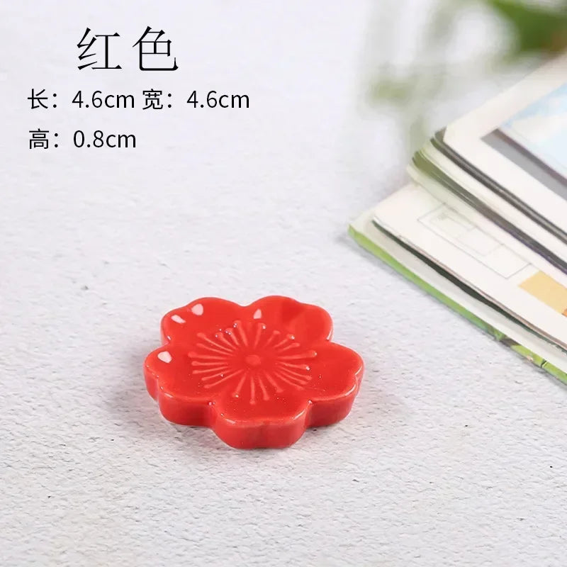 Red flower-shaped kawaii chopstick holder on a white surface with text providing dimensions.