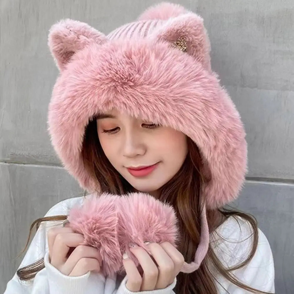 Person wearing a pink fluffy Kawaii hat with cat ears against a gray wall.