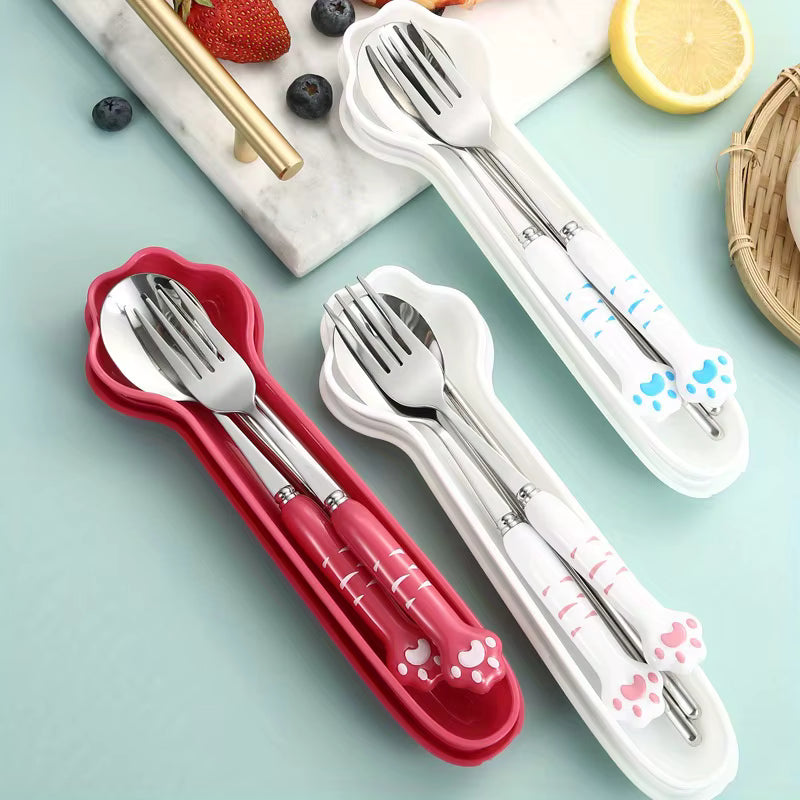 Set of silver kawaii utensils in red and white cases on a light blue background with fruits.