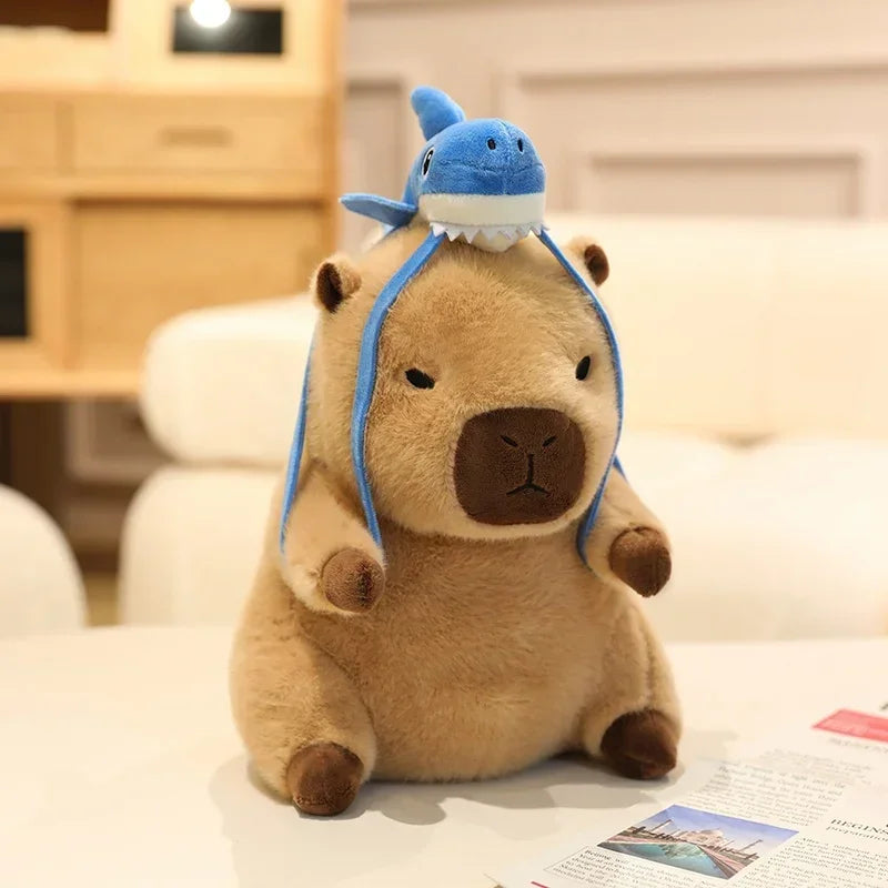 Kawaii plush toy with a blue hat resembling a shark on a light-colored surface.