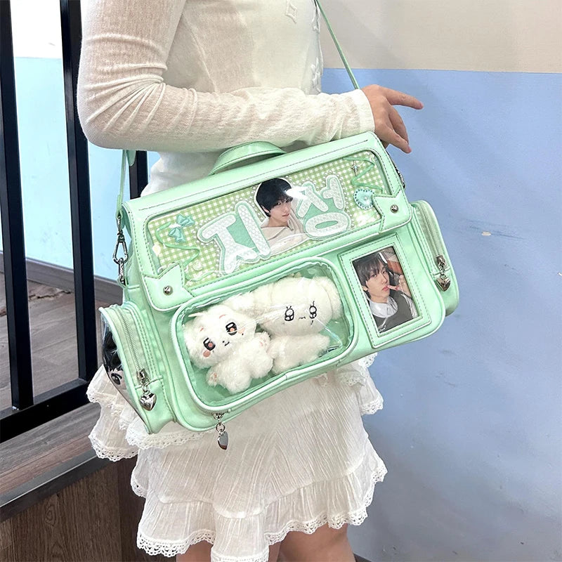 Person holding a green Kawaii handbag with plush toy and photos, against a light blue wall.
