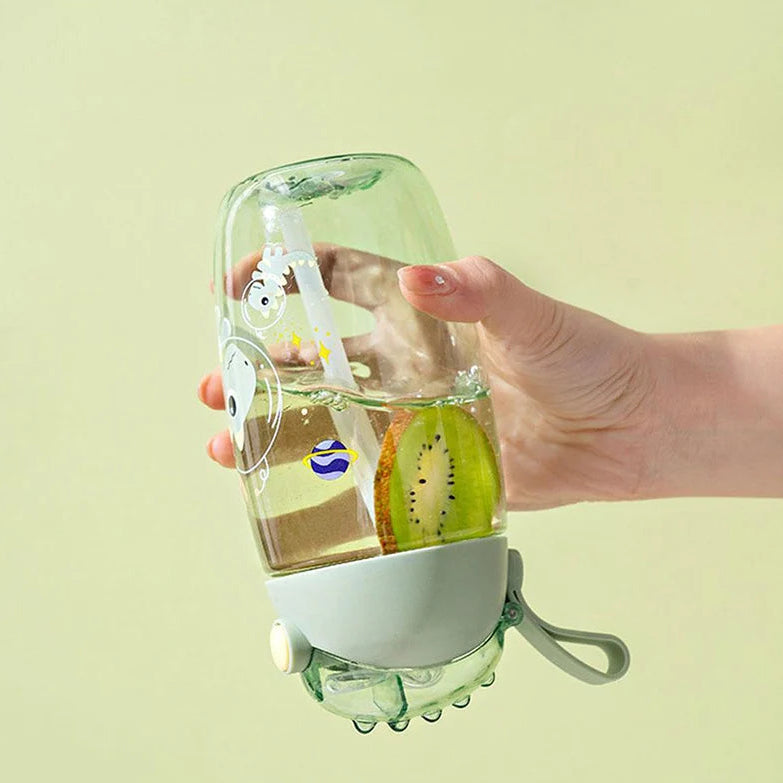 Hand holding a kawaii water bottle with kiwi slices inside, on a light green background