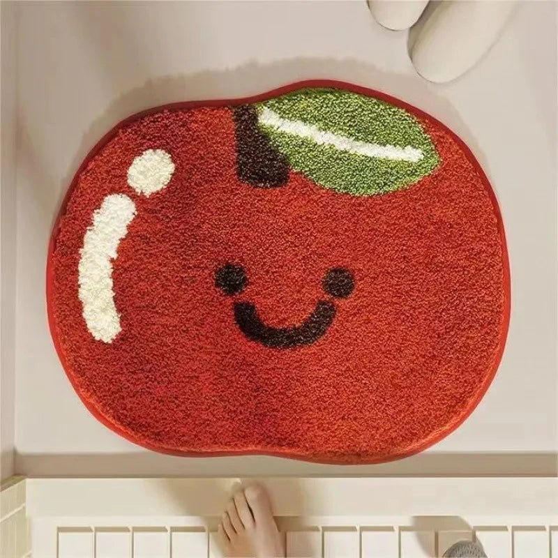 Red apple-shaped kawaii rug with a smiley face on a white floor.