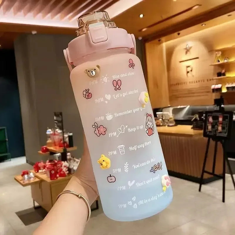 Pink kawaii water bottle with cartoon designs held in a hand, indoor setting