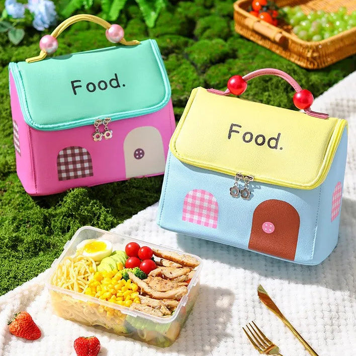 Two colorful kawaii lunch bags with 'Food' text, one pink and one blue, on a grassy background.