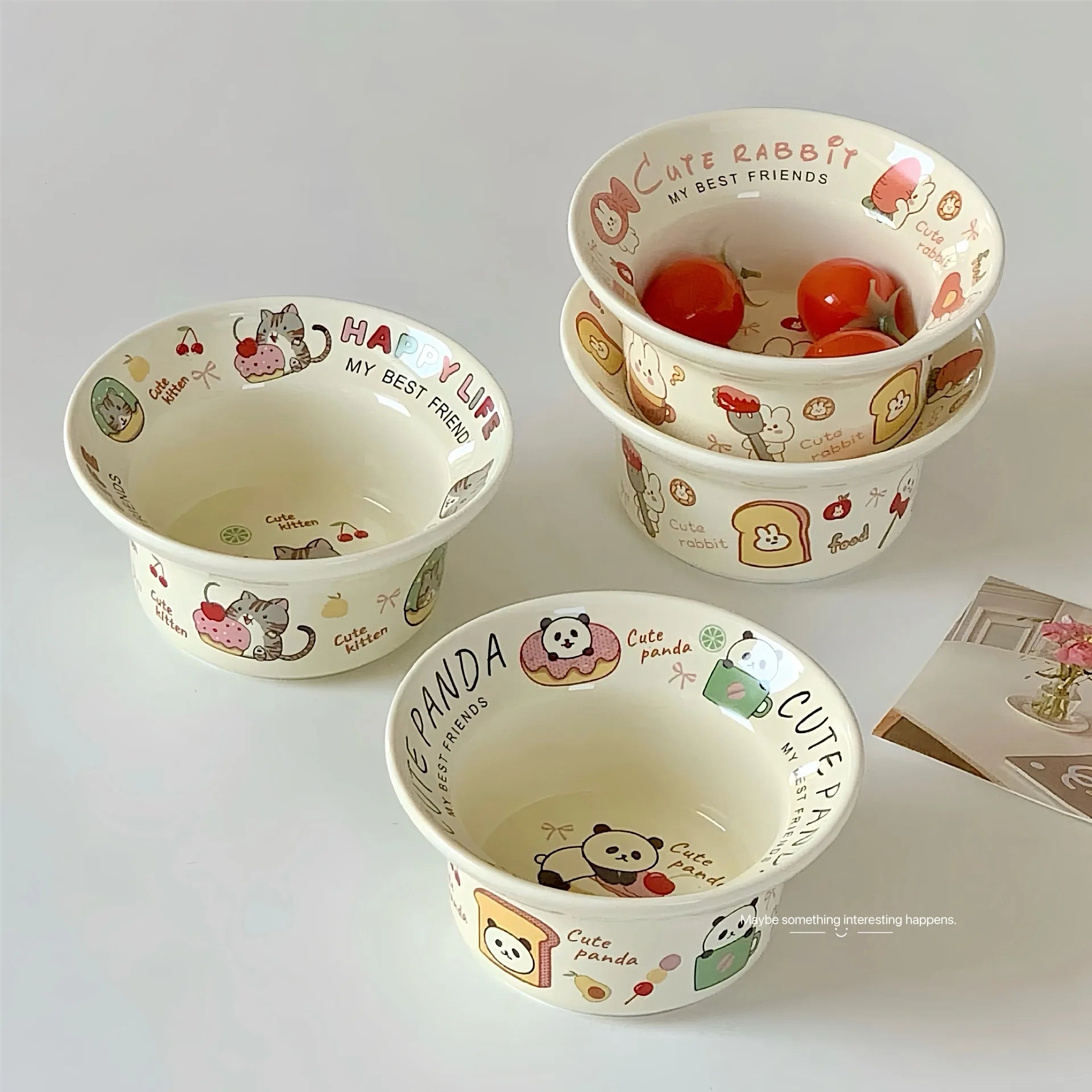 Set of three ceramic kawaii ramen bowls with cartoon designs on a white surface
