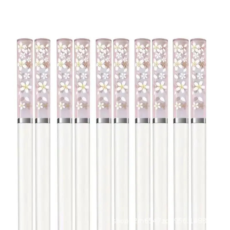 Set of white kawaii chopsticks with floral designs on the handles against a white background