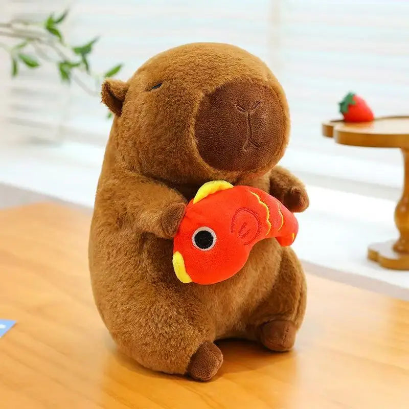 Brown kawaii plush toy resembling a beaver holding a red fish-shaped object on a wooden surface.