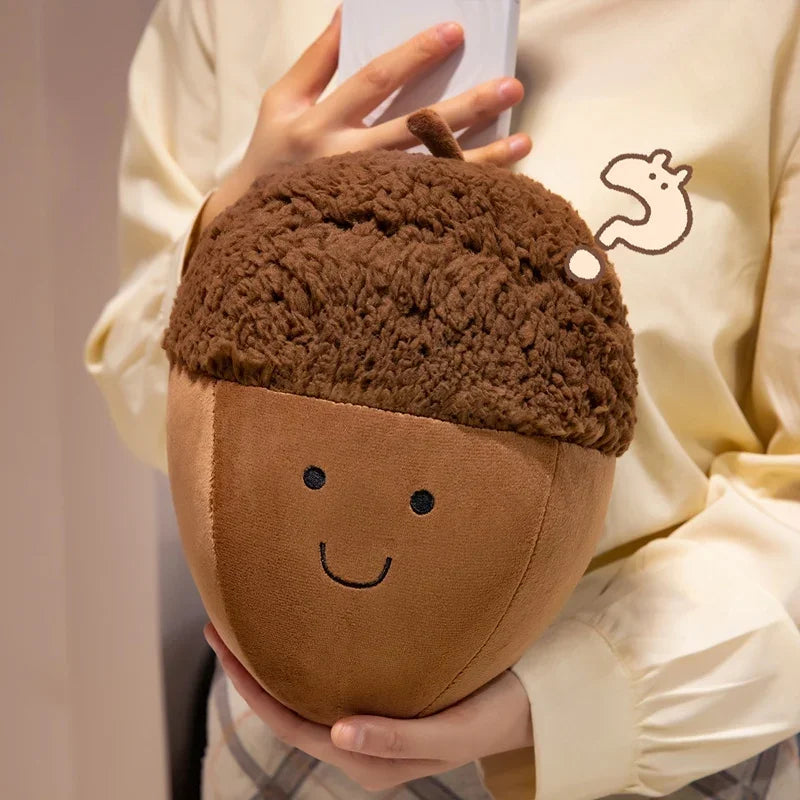 Person holding a kawaii plush acorn-shaped toy with a smiling face