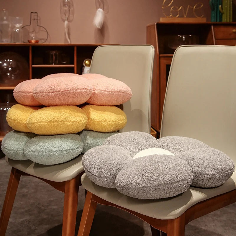 Stack of round kawaii cushions in various colors on a chair with a blurred indoor background.